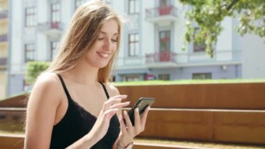 Genç Bayan kullanma şehir yürüyüş sırasında bir telefon