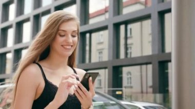 Genç Bayan kullanma şehir yürüyüş sırasında bir telefon