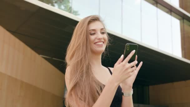 Fiatal hölgy segítségével a telefon, a város — Stock videók