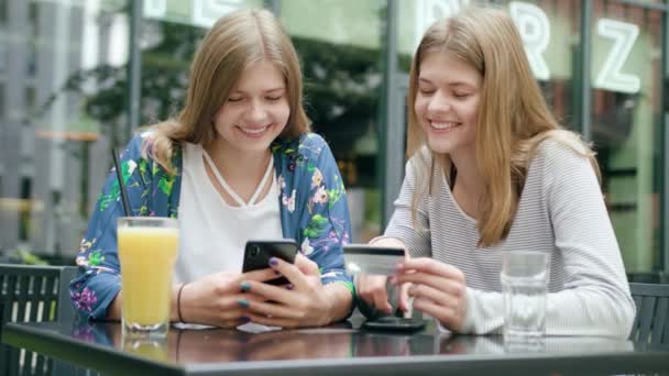 Mladé dámy pomocí telefonu a držení platební karty — Stock video