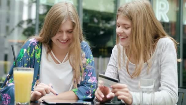 Jonge dames met behulp van een Tablet en houden van creditcard — Stockvideo