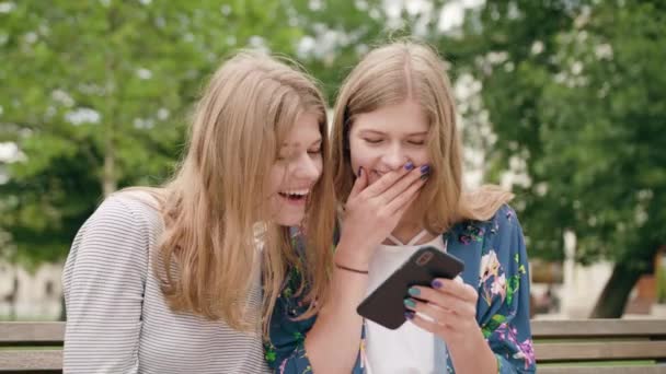 Unga damer använder en telefon i stan — Stockvideo