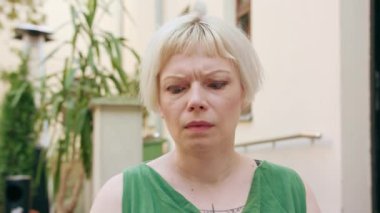 Dışarıda sinirli oturan sarışın genç kadın