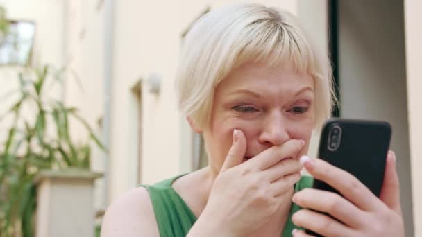 Jonge Blonde vrouw zitten buiten en het gebruik van de telefoon — Stockvideo