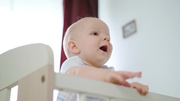 Niedliches Baby spielt in ihrem Kinderbett zu Hause — Stockvideo