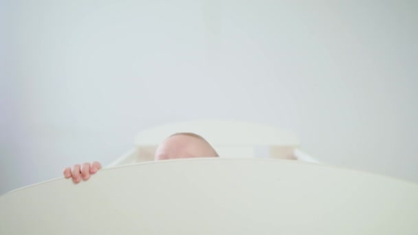 Симпатичный ребенок, играющий в детской кроватке дома — стоковое видео