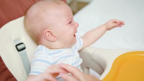 Lindo bebé llorando en la silla en casa — Vídeos de Stock