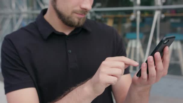 Hombre con barba usando un teléfono en la ciudad — Vídeo de stock