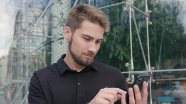 Hombre con barba usando un teléfono en la ciudad — Vídeo de stock