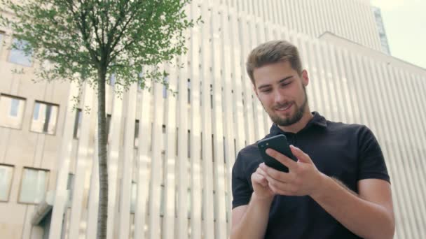 Uomo con la barba Utilizzando un telefono in città — Video Stock