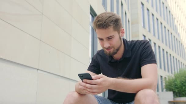 Homem com barba usando um telefone na cidade — Vídeo de Stock