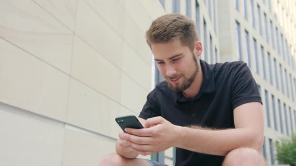 Hombre con barba usando un teléfono en la ciudad — Vídeos de Stock