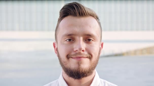 Joven con una camisa blanca sonriendo en la ciudad — Vídeos de Stock