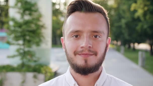Νεαρός άνδρας, φορώντας ένα άσπρο πουκάμισο χαμογελώντας στην πόλη — Αρχείο Βίντεο