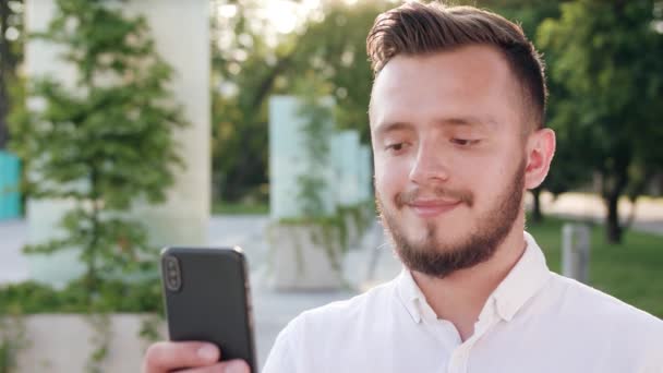 Ung Man använder en telefon i stan — Stockvideo