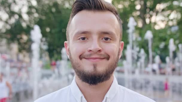 Jovem vestindo uma camisa branca sorrindo na cidade — Vídeo de Stock