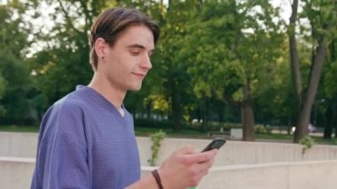 Yürüyüş ve şehirde bir telefonu kullanarak genç adam