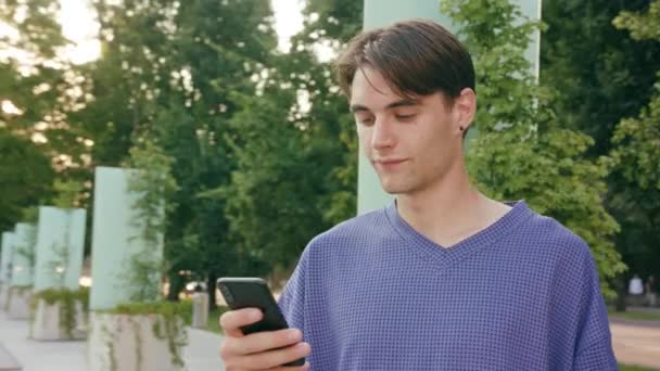 Jonge Man met behulp van een telefoon in de stad — Stockvideo