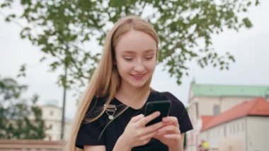 Genç Redhead kasabada bir telefonu kullanarak Lady