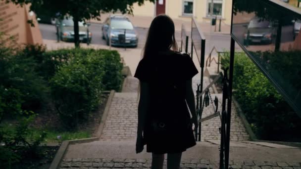 Fiatal vörös hajú hölgy séta le a lépcsőn, a város — Stock videók