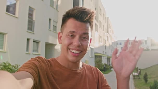 Joven saludando al teléfono en la ciudad — Vídeos de Stock