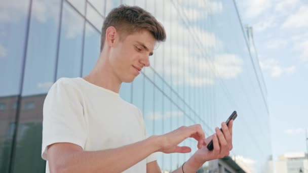 Joven usando un teléfono en la ciudad — Vídeos de Stock