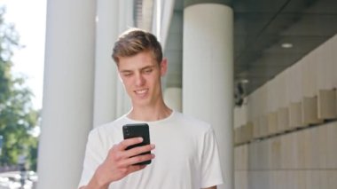Yürüyüş ve şehirde bir telefonu kullanarak genç adam