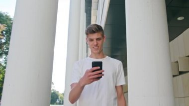 Yürüyüş ve şehirde bir telefonu kullanarak genç adam