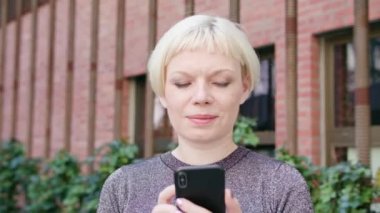 Genç sarışın Bayan kasabada bir telefon kullanma