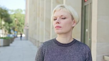 Şehirde mutlu gülümseyen sarışın kadın