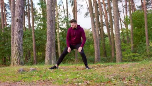 Junger Mann streckt sich im Wald — Stockvideo