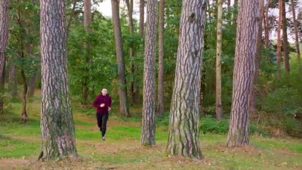 Jeune homme courant dans la forêt 