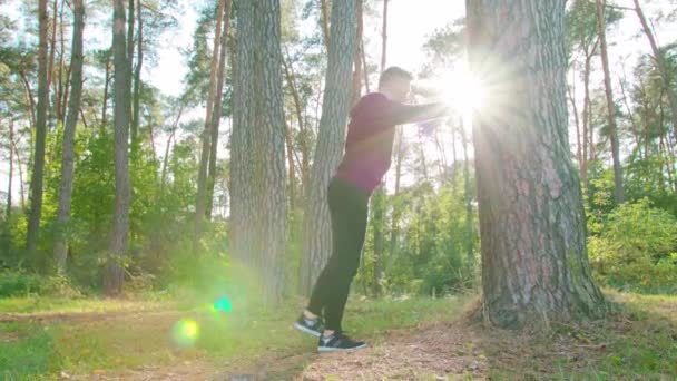 Jeune homme s'étirant dans la forêt — Video