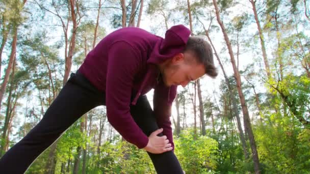 Ung man stretching i skogen — Stockvideo