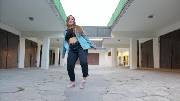 Mujer joven bailando en el patio — Vídeo de stock