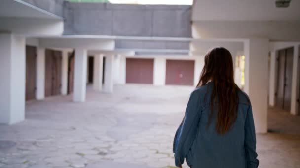 Молода жінка прогулянки у дворі — стокове відео