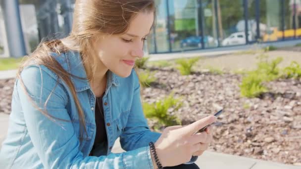 Giovane signora utilizzando un telefono in città — Video Stock