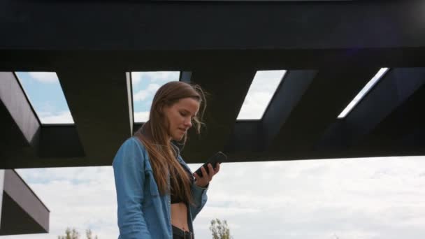 Jeune femme utilisant un téléphone en ville — Video