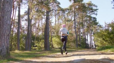 Ormanda koşu pembe saçlı Genç Bayan