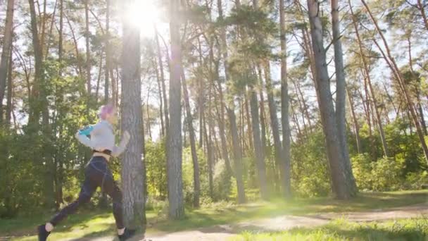 Młoda Pani z różowymi włosami Jogging w lesie — Wideo stockowe