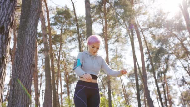 Молода леді з рожевим волоссям стрибати в лісі — стокове відео