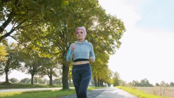 Jeune dame avec des cheveux roses Jogging dans les banlieues. Glitch — Video