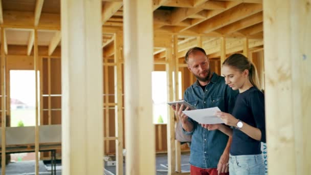 İki genç insanlar tartışırken bir ev inşaatı — Stok video