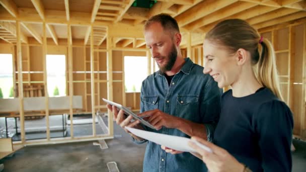 Dos jóvenes discutiendo la construcción de una casa — Vídeo de stock