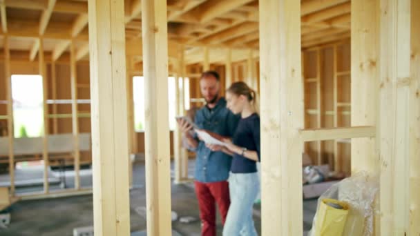 Dos jóvenes discutiendo la construcción de una casa — Vídeo de stock