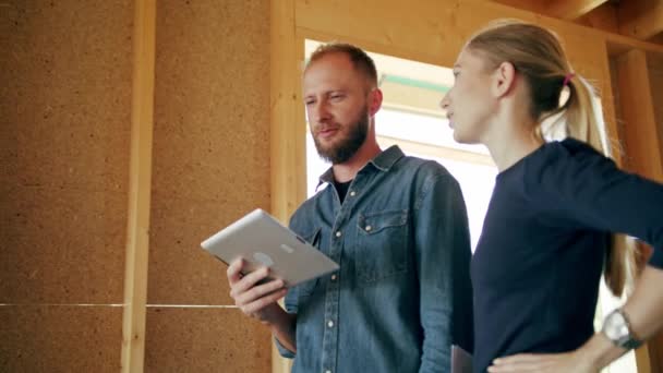 Dos Jóvenes Discutiendo Construcción Una Casa Dentro Casa Tiro Medio — Vídeo de stock