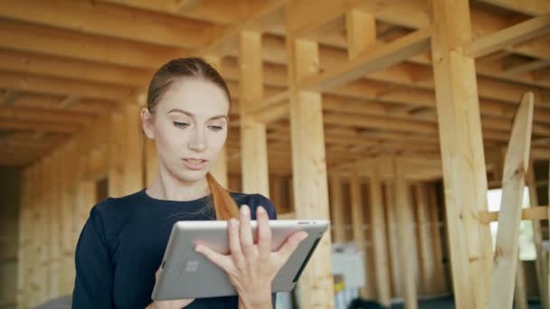 Joven dama usando tableta en casa en construcción — Vídeo de stock