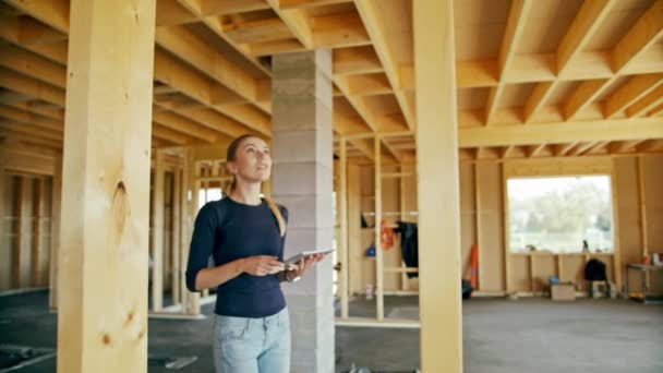 Jeune dame utilisant tablette dans la maison en construction — Video