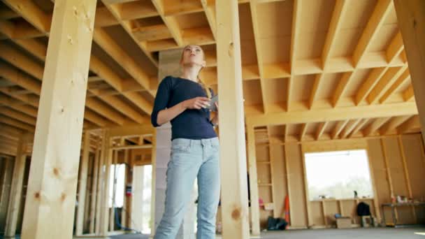 Fiatal hölgy segítségével tabletta a ház építés alatt — Stock videók