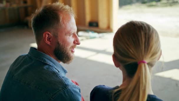 Zwei junge Leute diskutieren über den Bau eines Hauses — Stockvideo